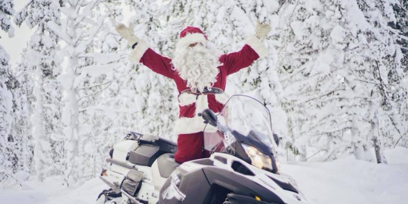 De kerstman op de sneeuwscooter in Lapland