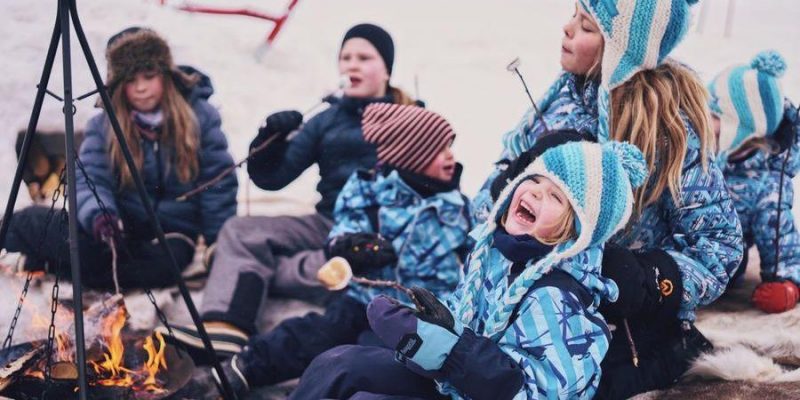 Kinderen genieten van Lapland bij een kampvuur
