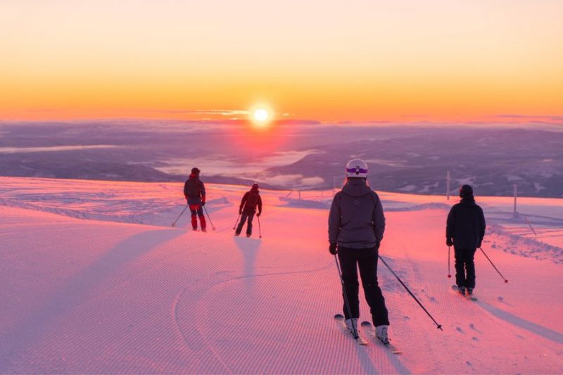 Groepje skiërs skiet de zonsondergang tegemoet in Norefjell