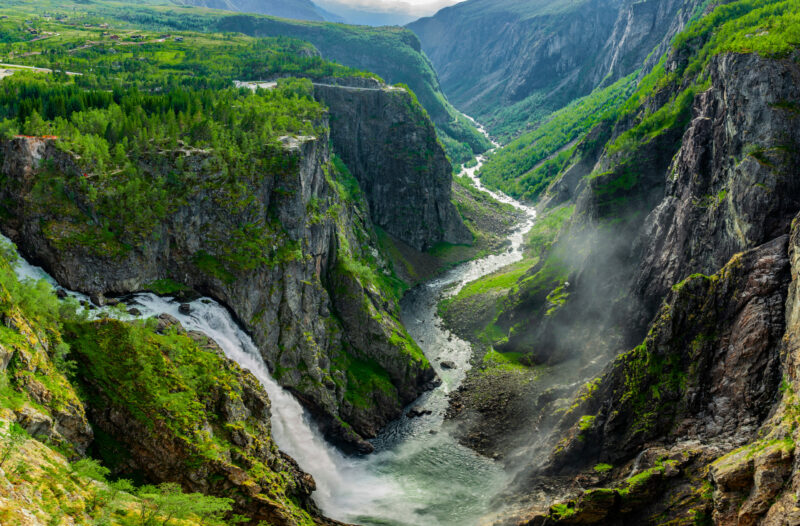 Het uitzicht over de Foringfossen waterval tussen twee steile, met groen begroeide bergwanden in Noorwegen.