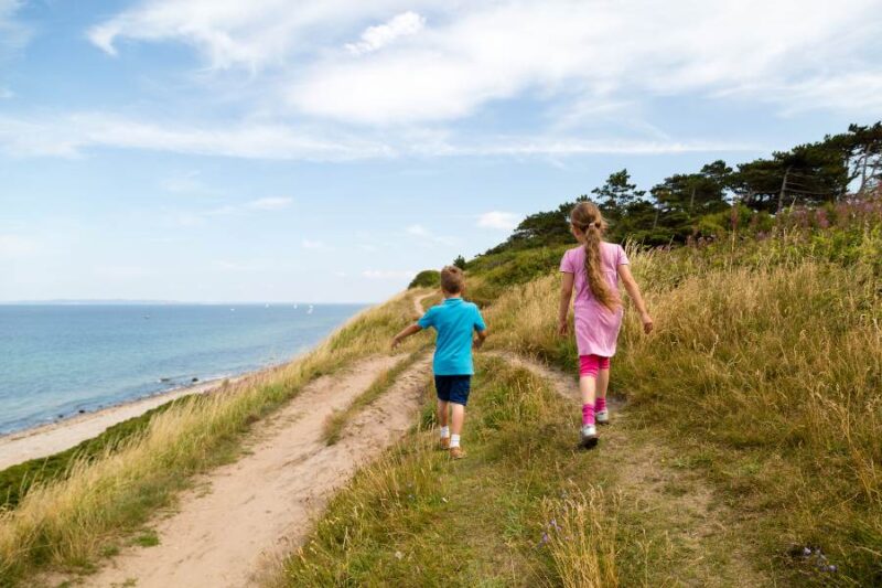 Kinderen wandelen langs de kust tijdens een vakantie in Denemarken